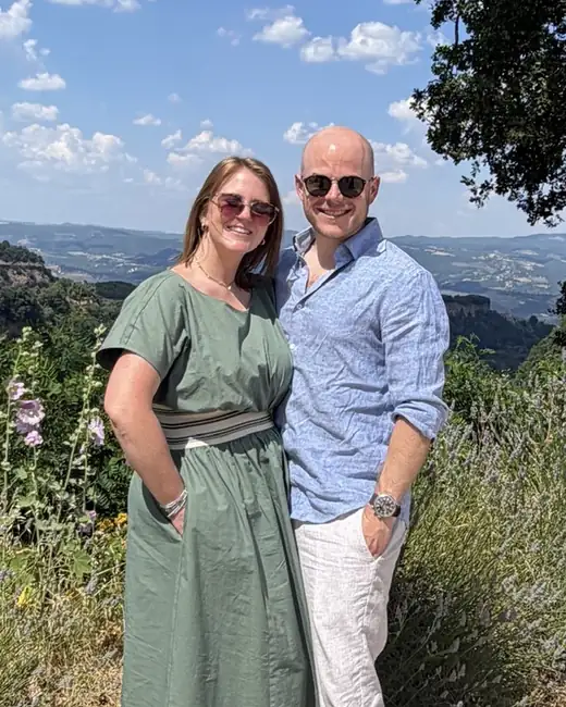 Stephanie and Alex Deo standing together on a hillside path lined with lavender